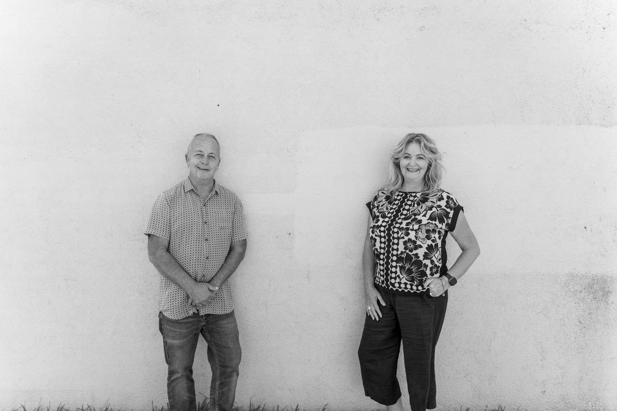 Lisa and Blair leaning against a white plastered wall