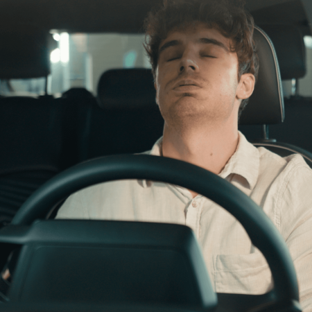 Man in parked car, eyes closed, head back, relaxing anger