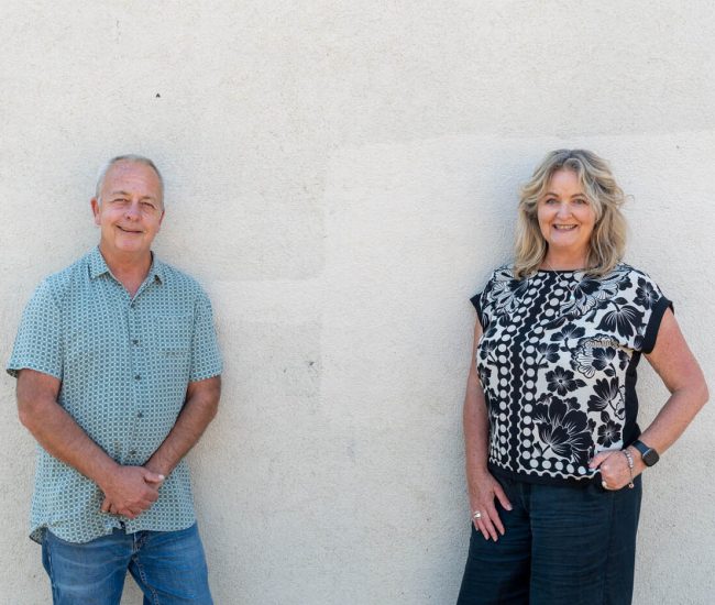 TRTP Practitioner, Blair and Lisa standing in front of a white exterior wall