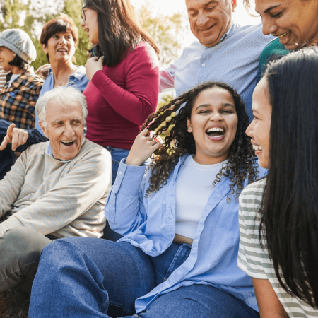 Group of people of all ages, sitting and standing, talking and laughing